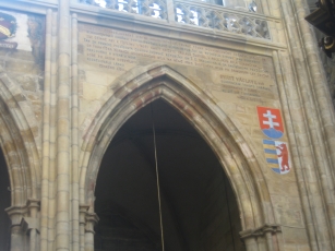 An archway with crests and inscription