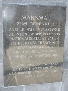 The plaque to the left of the gate into the Jewish memorial at Dachau