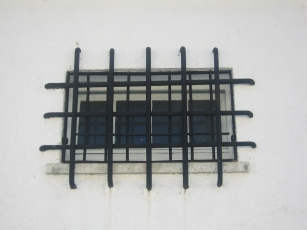 Double layers of iron bars over a window on the bunker, in the Dachau concentration camp